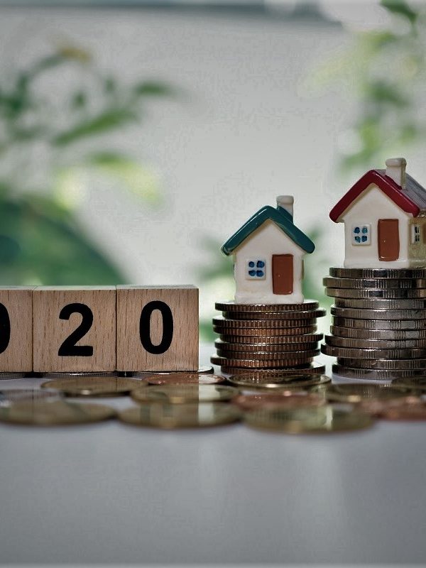 Wooden block year 2020 and mini house on stack coins using as business and financial concept