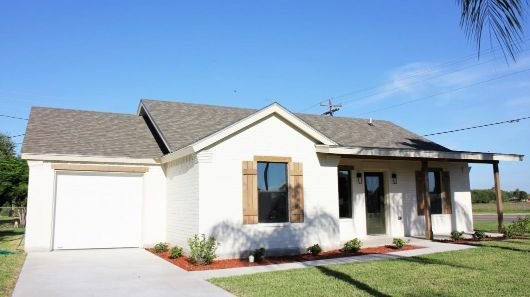 A South Texas smart home with a front porch and cream-colored brick facade.