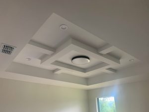 Energy-efficient lighting set in a detailed tray-style ceiling.