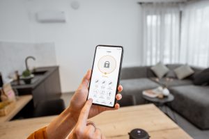 A woman secures her home using a smart home security phone application.