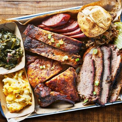 A barbeque platter sits on a rustic wooden surface.